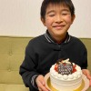 kukuluの誕生日ケーキを持つ息子