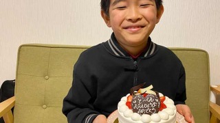 kukuluの誕生日ケーキを持つ息子