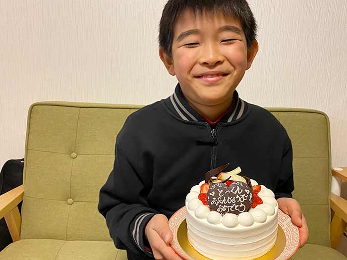 kukuluの誕生日ケーキを持つ息子