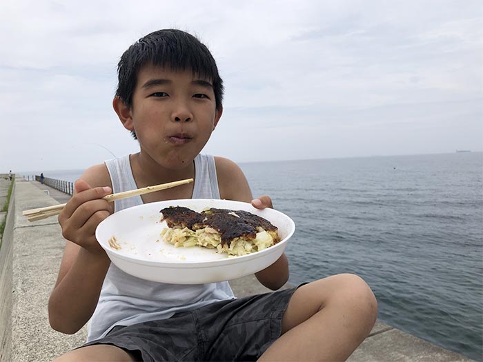 お好み焼きを海で食べる息子